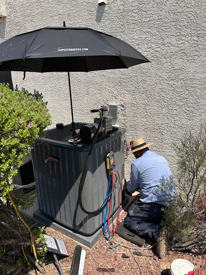 HVAC technician performing outdoor AC maintenance in Kaneohe Base